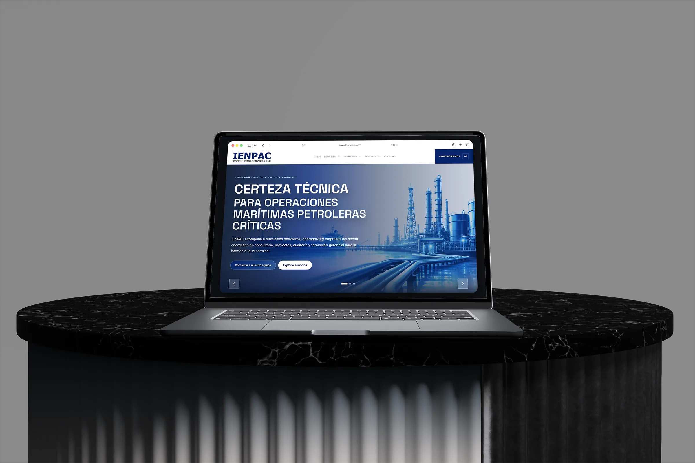 IENPAC consulting website displayed on a laptop above a black marble pedestal.