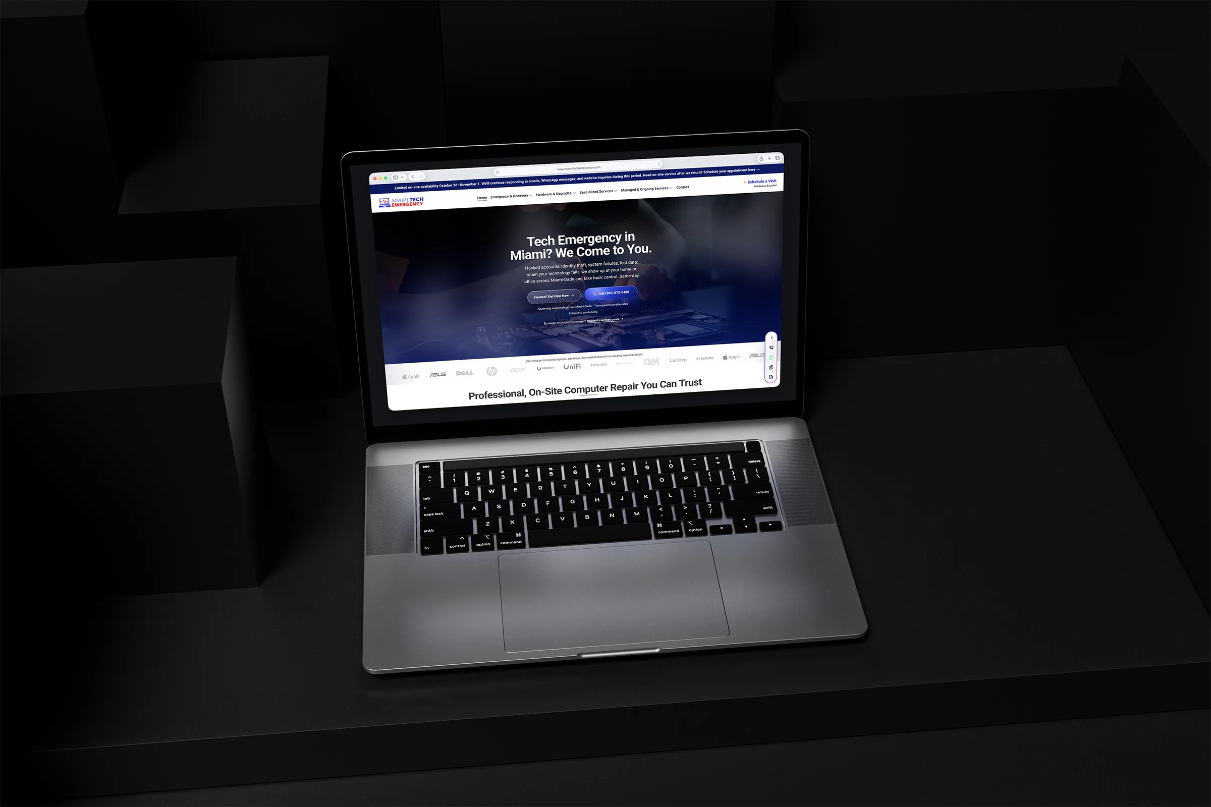 Miami Tech Emergency website displayed on a laptop in a dark geometric setting.