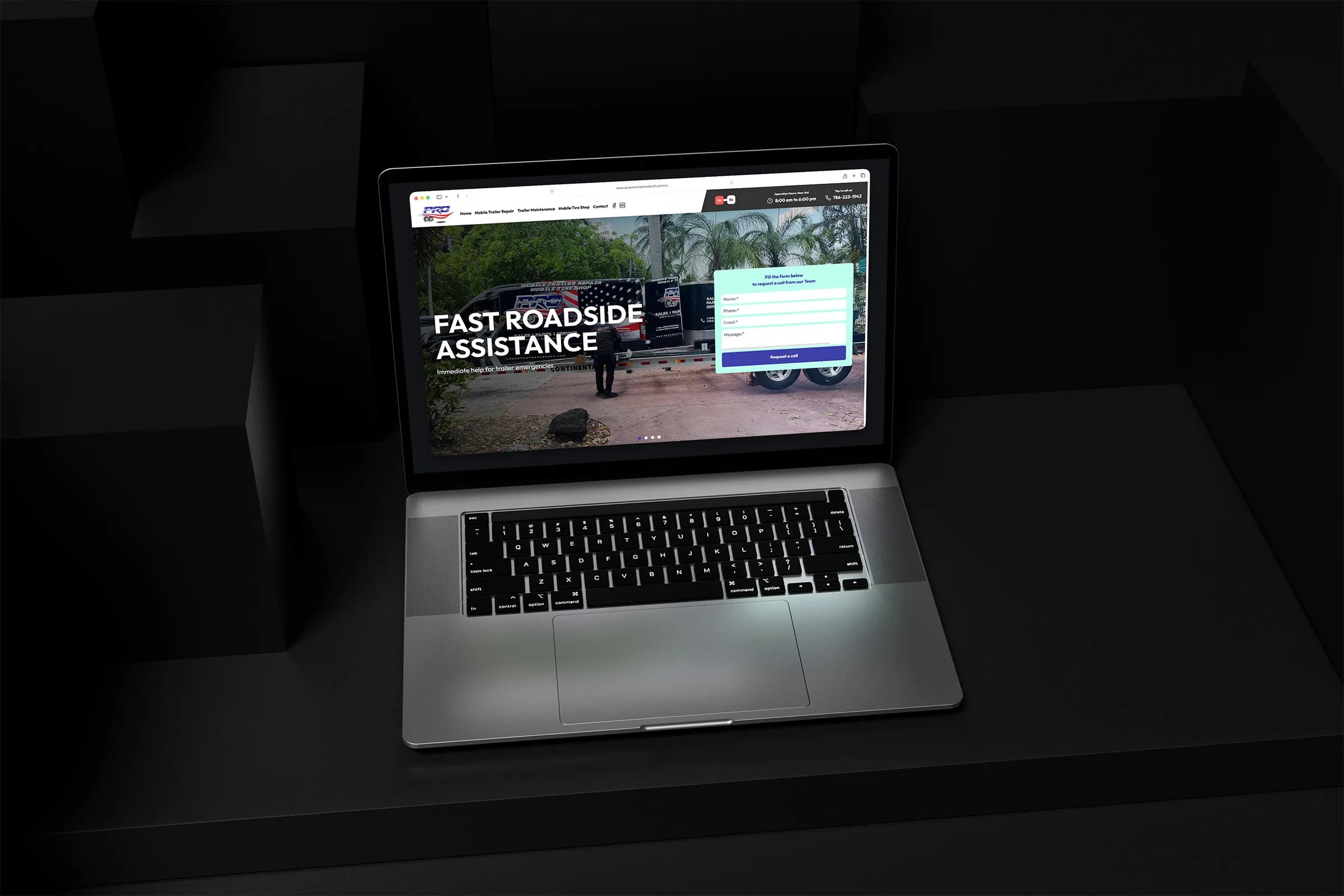 Pro American Trailers website displayed on a laptop in a dark geometric setting.
